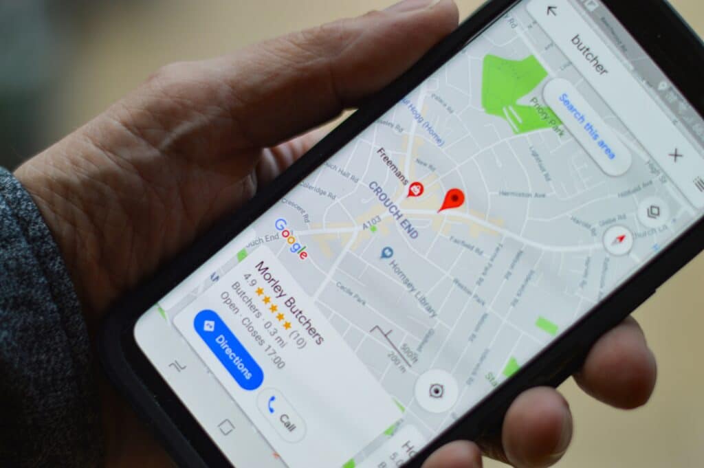 Uma mão segura um smartphone exibindo um aplicativo de mapas — veja como usar o Google Maps de forma inteligente durante suas viagens.